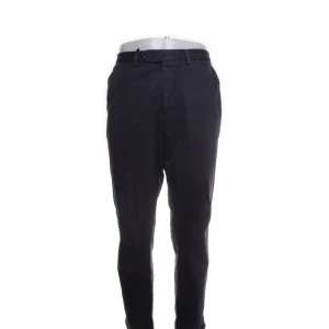 Oscar Jacobson byxor  - Snygga svarta chinos i normal passform. Perfekta för både vardag och fest. De har en klassisk design med knappar och dragkedja framtill. Materialet är mjukt och bekvämt, vilket gör dem idealiska för alla säsonger. Ett måste i garderoben för en stilren look!