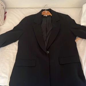 Svart kavaj - En ganska lång kavaj från H&M i storlek M.