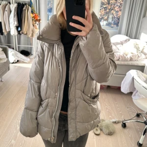 Grå dunjacka från Massimo Dutti - Säljer en snygg och varm grå dunjacka från Massimo Dutti. Jackan har en dragkedja framtill och stora fickor. Perfekt för kyliga höst- och vinterdagar.  Supermysig och stilren! Storlek S. Nypris 1899kr. Den är väl använd och har tecken på användning men inget jättetydligt vid första ögonkast men det syns mer om man kollar noga. Inga defekter vad jag har hittat (isåfall något pyttelitet jag missat) utan det är fläckar som säkert går bort i tvätt