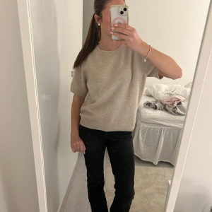 Beige kortärmad tröja - Säljer en stilren beige tröja med korta ärmar. Perfekt för vår och sommar! Tröjan har en normal passform och är gjord i ett mjukt material som känns skönt mot huden. Passar både till vardags och lite finare tillfällen. 🧡