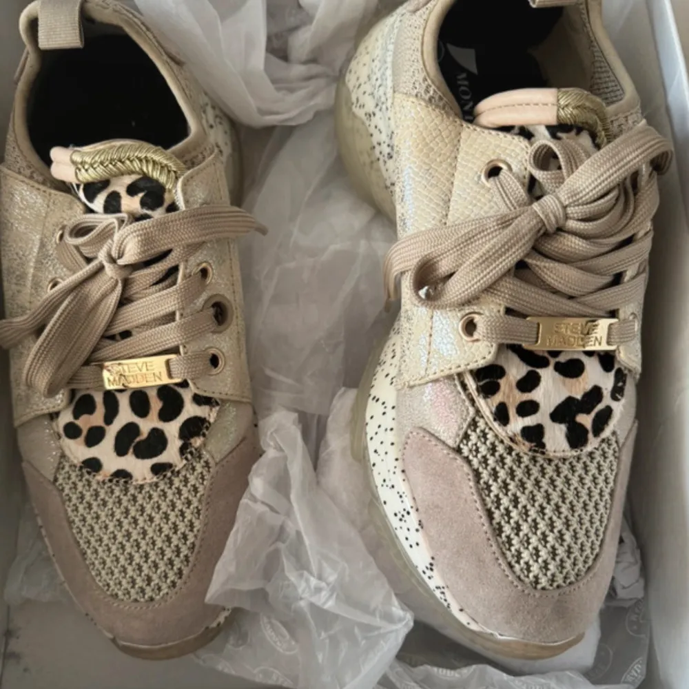 Säljer ett par Steve Madden sneakers i taupe multi. Skorna har ett coolt leopardmönster och är gjorda i mocka och tyg. De har snörning och en unik design med olika texturer. . Skor.