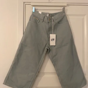 Blå/grå shorts från Eytys - Säljer ett par shorts från Eytys i modellen 'boyle twill sky'. De är i nytt skick med prislapp och har en loose passform med hög midja. Perfekta för vår och sommar! Shortsen är tillverkade i bomull och har en stilren design med fickor både fram och bak med eytys loggan innanför.