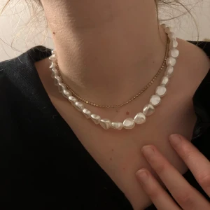 Pärlhalsband och guldhalsband - Säljer dessa två olika halsband. Den ena är ett guldhalsband som är justerbart, så stilrent! Det andra är ett vitt pärlhalsband med låsdetalj som antingen kan sitta fram eller bak, har en liten defekt men som knappt syns på (sista bild). 