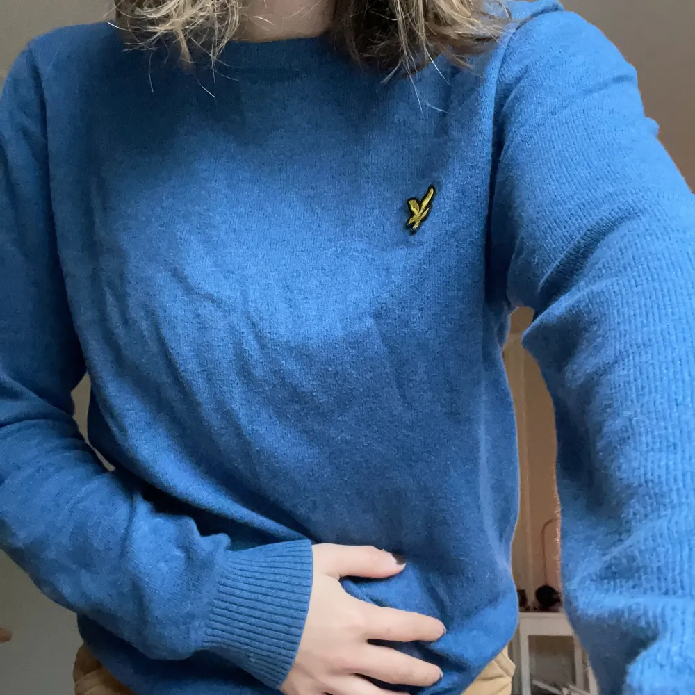 Säljer en blå tröja från Lyle & Scott i bra skick. Den har en gul fågel till logga på bröstet och ribbade muddar. Perfekt för höst och vår! Observera en liten grön fläck på ärmen. Passar både till vardags och lite finare tillfällen. Finns i mörk blå och grå på min sida. 🩵. Neuletakit & Villapaidat.