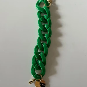 Grönt armband från By Jolima - Snyggt grönt armband från By Malina med stora länkar och en liten guldpläterad berlock. Perfekt för att ge en färgklick till din outfit. Lätt att matcha med andra smycken och accessoarer. Passar både till vardags och fest!