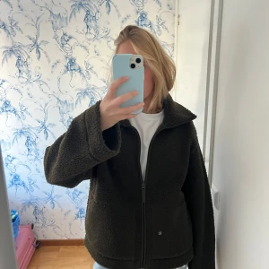 Mörkgrön teddyjacka - Mysig mörkgrön teddyjacka med dragkedja framtill. 