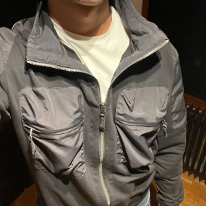 Svart/grå jacka från Parajumpers - Säljer en snygg svart jacka från Parajumpers i mycket bra skick. Köpt i Danmark 2022 och är helt oanvänd. Storlek XL men passar perfekt på mig som har storlek M. Det är bara att ställa frågor om det är några oklarheter!