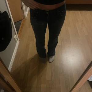 Blå jeans från Victoria Beckham - Snygga blå jeans från Victoria Beckham med en cool kronbrodering på bakfickan. De har en normal passform och är perfekta för både vardag och fest. Jeansen är i bra skick och har en klassisk femficksdesign. Bootcut✨