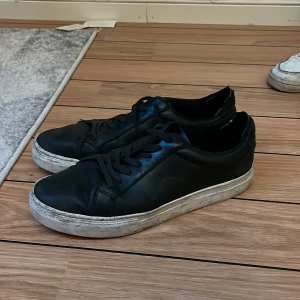 Svarta sneakers från Vagabond - Säljer ett par svarta sneakers från Vagabond i bra skick. De har en vit sula som är lite smutsig men annars i fint skick. Perfekta för vardagsbruk och passar till det mesta. Skorna har snörning och är gjorda i skinn.