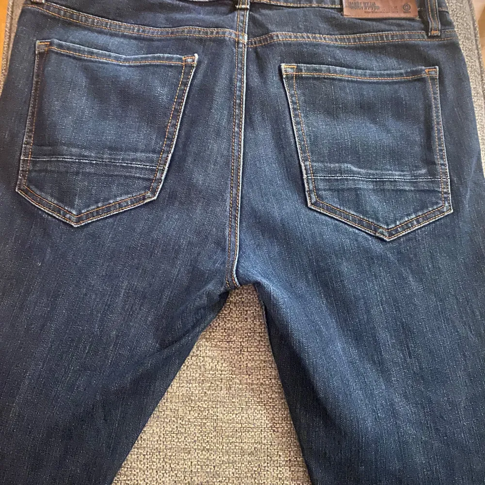 Säljer ett par mörkblå jeans i regular fit med stretch. De har klassisk femficksdesign och en knappgylf. Perfekta för vardagsbruk och passar till de flesta tillfällen. Jeansen är i bra skick och redo för en ny ägare!. Jeans & Byxor.