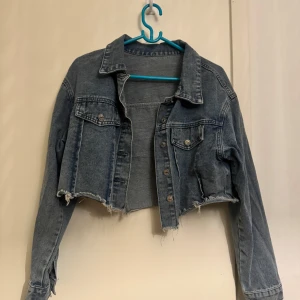 Kort jeans jacka  - Jätte fin jeans jacka som är kort i längden skulle vart jätte fint tex i en svart tajt klänning. Jeans jackan är oanvänd och är som en helt ny köpt från butiken. 