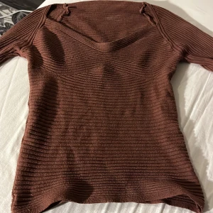Brun ribbad tröja - Säljer en brun ribbad tröja med långa ärmar. Tröjan har en stilren design och är perfekt för kyligare dagar. Den är tillverkad i ett mjukt och bekvämt material som ger en skön passform.