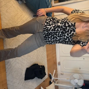 Svin snygg topp - Snygg svartvit blus med leopardmönster och knappar framtill. Perfekt för en trendig look. Säkjer då den är för tajt i bysten