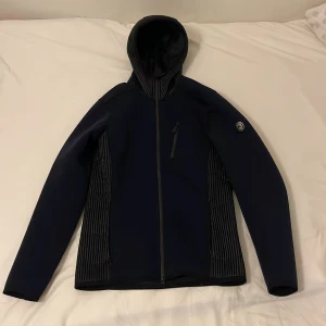 J Lindeberg Jacka  - Perfekt för höst/vår. jackan/ är i ny skick använt 2 gånger kan avsändas både inomhus,  joggingrundor och utomhus 