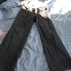 Svarta jeansbyxor från H&M - Snygga svarta jeansbyxor med klassisk design. De har en rak passform och är perfekta för en avslappnad stil. Byxorna har fickor både fram och bak samt en dragkedja och knapp i midjan. Från H&M