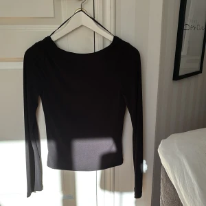 Svart långärmad topp från BikBok - Snygg svart långärmad topp från BikBok med rund halsringning. Öppen i ryggen. 