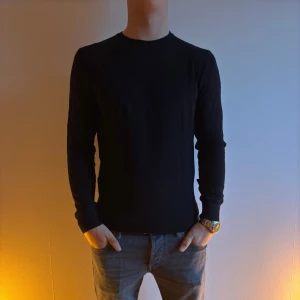 Mango tröja - Snygg svart långärmad tröja med en enkel och stilren design. Perfekt för en minimalistisk look och passar bra till jeans eller chinos. Tröjan har en normal passform och är tillverkad i ett mjukt material för extra komfort.