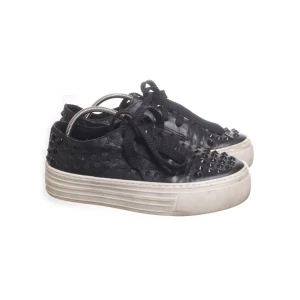 Svarta sneakers med nitar - Coola svarta sneakers med nitar och tjock vit sula. Skorna har snörning och en unik design med nitar över hela ovandelen. Perfekta för att ge en edgy touch till din outfit.