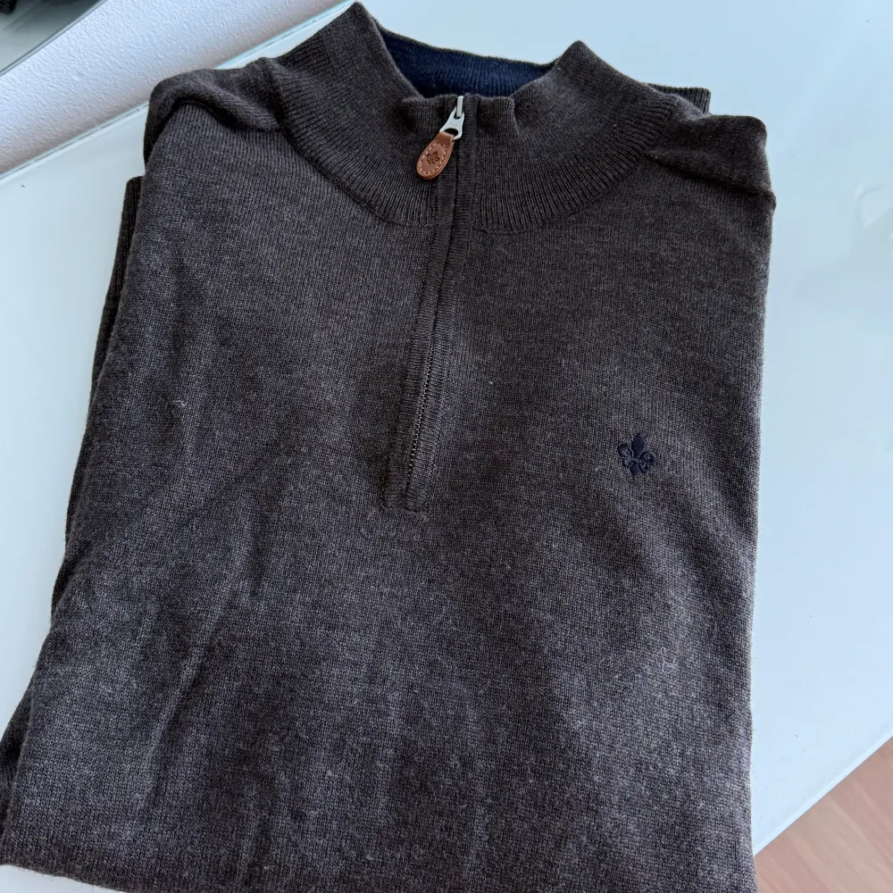 Stickad tunnare half zip tröja i Merinoull. Mörkbrun melerad med marinblå innerkrage. Storlek M, nypris 1799kr. . Neuletakit & Villapaidat.