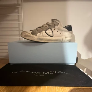 Philippe model sneakers  - Snygga vita sneakers från Philippe Model med en stilren design. Skorna har snörning och en diskret logga på sidan. Perfekta för en avslappnad stil.Dust bag och box medföljer