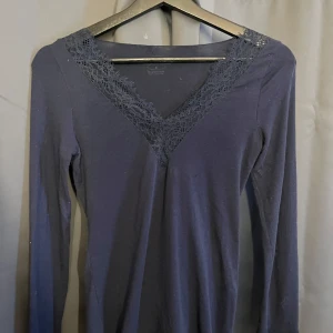 Mörkblå intimissimi långärmad tröja med spets - Snygg mörkblå topp med långa ärmar och v-ringad spetsdetalj vid halsen och ärm. Nästan ointill oanvänd. Köpt på intimissimi butik. Nypris : 459 Mittpris: 299