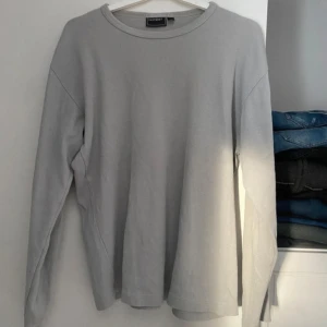 Grå tröja från Eastwest - Säljer en stilren grå tröja från Eastwest i storlek S. Tröjan har långa ärmar och en rund halsringning. Perfekt för en avslappnad look.