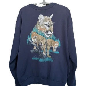Mörkblå sweatshirt med puma-tryck - Mörkblå vintage tröja. Köpt secondhand, men är i bra skicka. Skulle säga att storleken är L.