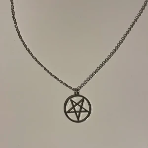 Silverfärgat halsband med pentagram - Silverfärgat halsband med pentagram från blue fox (tror jag) använt endast en gång. Kedjan är ungefär 70cm lång och berlocken ungefär 3cm i diameter.