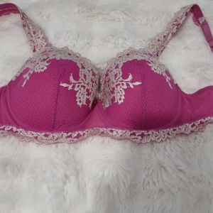 Intimissimi bh  - Elegant Intimissimi rosa bh med vacker spets och broderade blommönster i beige. Justerbara axelband och hakknäppning bak för perfekt passform. Perfekt för att känna sig extra fin.