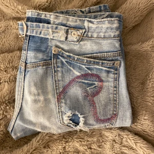 Lågmidjade blå jeans  - Säljer ett par Lågmidjade straight blå jeans från Replay med slitna detaljer. Säljer de eftersom de inte kommer till användning❤️midja=27 ben=34