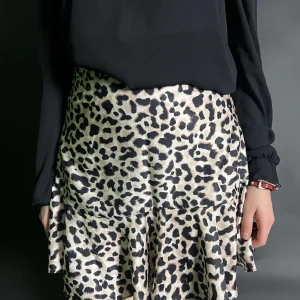 Leopardmönstrad kjol - Trendig leopardmönstrad kjol med volangdetaljer. Perfekt för att ge din outfit en djärv touch. Kjolen har en smickrande passform och är lätt att matcha med olika toppar.