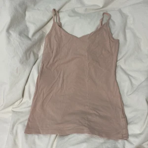 Beige/rosa linnetopp från 157 - Säljer en beige/rosa linnetopp från 157 i storlek M. Toppen är tillverkad av 95% bomull och 5% elastan, vilket ger en mjuk och stretchig känsla. Perfekt för varma dagar eller som lager under andra plagg.