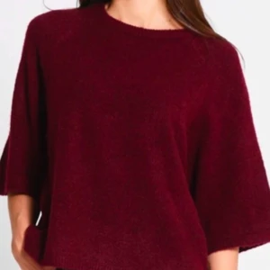 Vinröd tröja med trekvartsärm - Säljer en mysig vinröd tröja med trekvartsärm. Perfekt för höst och vinter. Tröjan har en lös passform och är tillverkad i ett mjukt material som ger en skön känsla. Passar bra till både jeans och kjol.