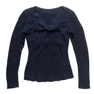 Svart långärmad vintage topp med spetsdetalj - Snygg svart långärmad topp med spetsdetalj vid halsringningen och knytband framtill. Passar en XS eller S bäst. 