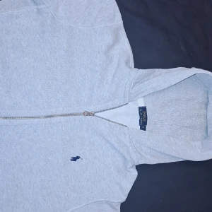 Grå zip hoodie från Polo Ralph Lauren - Säljer denna nya grå zip hoodie från Polo Ralph Lauren med det klassiska logotypbroderiet på bröstet. Perfekt för en grisch look. 100% äkta