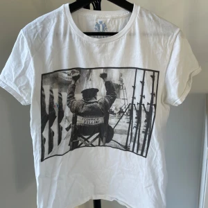 L’ELITÉ 55 T-shirt - Säljer en vit t-shirt från L’ELITÉ 55 med ett coolt svartvitt tryck av Federico Fellini på framsidan. Är storlek M men skulle påstå passar storlek S också. Vid frågor eller funderingar hör gärna av dig! 🙏