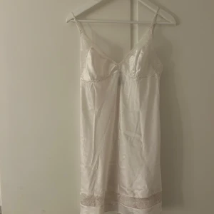 Vitt satinnattlinne med spetsdetaljer - Elegant vitt nattlinne i superfint skick från Victoria’s secret. Nattlinnet har fina spetsdetaljer vid byst och nederkant som ger en romantisk touch. Perfekt för speciella tillfällen🥰 nästintill oanvänt