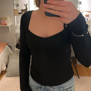 Svart långärmad topp - Snygg svart långärmad topp med en elegant v-ringad design. Perfekt för en stilren look, passar bra med jeans eller kjol. Säljer pågrund av att den är förstor, aldrig använd! Inga fläckar, kan se ut som det då spegeln är smutsig. Köpt från Nelly. Nypris 199