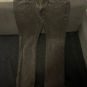 Grå jeansbyxor - Snygga grå jeansbyxor med en klassisk straight passform. De har en midwaist design och är perfekta för en avslappnad stil. Byxorna har dragkedja och knappar framtill.