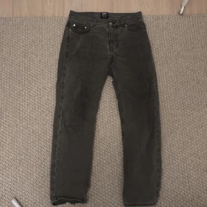 Grå jeans från Sweet SKTBS - Snygga grå jeans från Sweet SKTBS med en klassisk femficksdesign. De har en rak passform och är tillverkade i ett slitstarkt material, perfekt för vardagligt bruk. Märkeslappen på baksidan ger en cool touch.