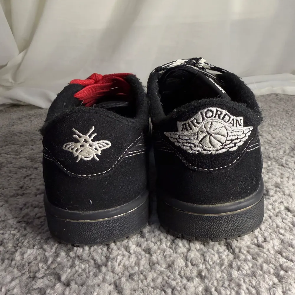 Jordan 1 Low i svart, storlek 40. Lätta tecken på användning, skick 8/10. Klassisk design och hög komfort, perfekt för både vardag och stiliga looks. Färg svart, röd, och vit. . Kengät.