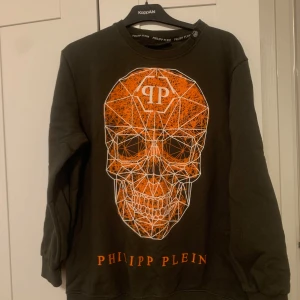 Grön tröja med orange dödskalle från Philipp Plein - I storlek XXL men skulle säga att den passar mer en M och används några gånger så är i fint skick. 