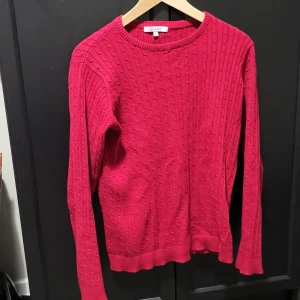 Röd stickad tröja från Isolde - Säljer en snygg röd stickad tröja från Isolde. Tröjan har ett diskret mönster och långa ärmar, perfekt för kyligare dagar. Den är både stilren och bekväm, ett måste i garderoben! 🔥