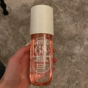 Brazilian Crush Cheirosa 68 från Sol de Janeiro - Parfymmist med doft av brasiliansk jasmin och rosa drakfrukt. Flaskan är genomskinlig med rosa vätska och har en vit kork. Perfekt för en fräsch och exotisk känsla.