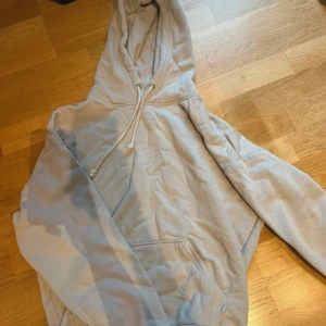 Beige  hoodie från BikBok - Säljer en beige hoodie från BikBok i storlek XS. Den har en klassisk design med en stor ficka framtill och justerbar huva med dragsko. Perfekt för en avslappnad stil. 🩵aldrig använd 
