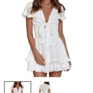 Student klänning - Köpte för min student 2025, men passade inte och det är jobbigt att returnera. Det är en vit kortklänning med knyt framtill och volangdetaljer. Klänningen har korta ärmar och en v-ringad design som ger en somrig känsla. Perfekt för studenten! 😍😍