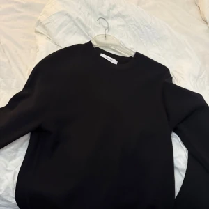 Svart tröja med knappar - Snygg svart tröja med knappar på axeln. Perfekt för en stilren look.  Från brothers aldrig använd. Nypris 1199