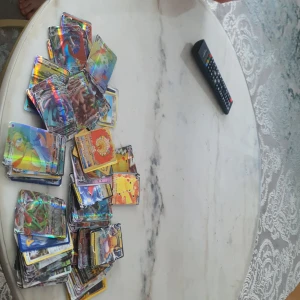  Pokémonkort 75 styck  - Stor samling av Pokémonkort med många holografiska och färgglada kort. Perfekt för samlare eller Pokémon-entusiaster som vill utöka sin kollektion. Innehåller flera olika Pokémon och korttyper.