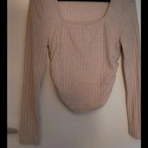 Beige ribbad långärmad topp - Säljer en stilren beige ribbad topp med långa ärmar. Den har en fyrkantig halsringning och är perfekt för både vardag och fest. ❤️