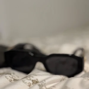Svarta solglasögon med rektangulära bågar - Snygga svarta solglasögon med rektangulära bågar. Perfekta för en stilren look. De har en klassisk design som passar till många olika outfits.
